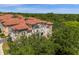 Stunning exterior view of a multi-story home with a red tile roof and lush green landscaping at 3508 Porta Romano Way, Lake Mary, FL 32746