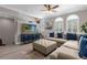 Cozy living room with large sectional sofa, ceiling fan, staircase, and an ottoman at 3508 Porta Romano Way, Lake Mary, FL 32746