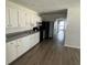 A kitchen with white cabinets, grey counter tops, and an open entrance to a hallway at 4204 Columbia St, Orlando, FL 32811