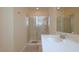 Bright bathroom featuring a glass-enclosed shower, a large mirror, and a spacious vanity with a sleek countertop at 4858 Magnetite Loop, Mount Dora, FL 32757