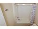 Clean bathroom features a bathtub and shower combination with a white tiled wall and patterned shower curtain at 4858 Magnetite Loop, Mount Dora, FL 32757