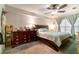 Bedroom featuring a wooden framed bed, ceiling fan, large window, and a dark wood dresser at 4890 Conway Rd # 66, Orlando, FL 32812