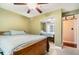Bedroom features mirrored closet doors, bed, ceiling fan, light green walls, and carpet at 4890 Conway Rd # 66, Orlando, FL 32812