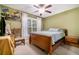 Bedroom with a ceiling fan, double-hung window, bed, carpet, and a wood nightstand at 4890 Conway Rd # 66, Orlando, FL 32812
