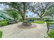 Community courtyard with a tiered fountain, benches, lush landscaping, and trees at 4890 Conway Rd # 66, Orlando, FL 32812