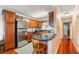 Well-lit kitchen with wood cabinets, black countertops, stainless steel refrigerator, and hardwood floors at 4890 Conway Rd # 66, Orlando, FL 32812