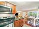 Updated kitchen area featuring stainless steel appliances, cherry wood cabinets, and an adjoining dining area at 4890 Conway Rd # 66, Orlando, FL 32812