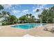 Community swimming pool surrounded by a deck, lounge chairs, and mature trees at 4890 Conway Rd # 66, Orlando, FL 32812