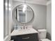 Modern bathroom with a stylish vanity, round mirror, contemporary light fixture, and a toilet at 503 Savona Ct, Altamonte Springs, FL 32701