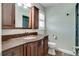 Bathroom featuring a dark wood vanity with granite countertops, modern fixtures, and a walk-in shower at 503 Savona Ct, Altamonte Springs, FL 32701