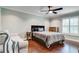 Cozy bedroom featuring a ceiling fan, hardwood floors, and a comfortable sitting area near a bright window at 503 Savona Ct, Altamonte Springs, FL 32701