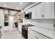 Bright kitchen with white cabinets, stainless steel appliances, and gorgeous countertops open to dining area with wood beam accents at 503 Savona Ct, Altamonte Springs, FL 32701