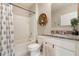 A well-lit bathroom showcases a vanity with granite countertops and a shower with blue patterned curtain at 6808 Cranes Roost Rd, Harmony, FL 34773