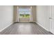 A serene bedroom featuring views of water, curtains, and modern gray floors at 6808 Cranes Roost Rd, Harmony, FL 34773