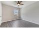 A bright bedroom featuring modern gray floors, a ceiling fan, and ample natural light at 6808 Cranes Roost Rd, Harmony, FL 34773