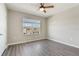 A bright, well-lit bedroom featuring modern gray floors, a ceiling fan, and ample natural light at 6808 Cranes Roost Rd, Harmony, FL 34773