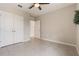Bright bedroom features tile floors, ceiling fan, and closet space at 6808 Cranes Roost Rd, Harmony, FL 34773