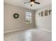 A serene bedroom with neutral walls and large tile floors complemented by a decorative wreath and ceiling fan at 6808 Cranes Roost Rd, Harmony, FL 34773