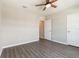 A bright bedroom with gray floors featuring a ceiling fan and views into another room at 6808 Cranes Roost Rd, Harmony, FL 34773