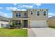 Charming two-story home features a welcoming front porch, two-car garage, and well-manicured lawn at 6808 Cranes Roost Rd, Harmony, FL 34773