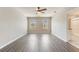 Main bedroom features wood-look floors, ceiling fan, two windows, and access to private bathroom at 6808 Cranes Roost Rd, Harmony, FL 34773
