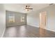 Bright main bedroom features wood-look floors, two windows, ceiling fan, and ensuite bathroom at 6808 Cranes Roost Rd, Harmony, FL 34773