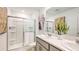 Bathroom featuring double sinks, a walk-in shower with glass door and decorative wall art at 7807 Waterscape Dr, Groveland, FL 34736