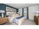 Comfortable bedroom with modern furnishings and blue accent wall with decorative picture frames at 7807 Waterscape Dr, Groveland, FL 34736