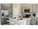 Modern kitchen with stainless steel appliances, grey cabinets, quartz countertops, and a large island at 7807 Waterscape Dr, Groveland, FL 34736