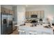 Modern kitchen with stainless steel appliances, gray cabinetry, and a large island at 7807 Waterscape Dr, Groveland, FL 34736