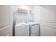 Compact laundry room with white appliances and a wire shelf for storage and organization at 7807 Waterscape Dr, Groveland, FL 34736