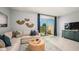 Bright living room with a neutral sectional couch, modern decor, and sliding glass door to patio at 7807 Waterscape Dr, Groveland, FL 34736