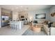 Open concept living space with kitchen island, stainless steel appliances, and neutral toned modern furniture at 7807 Waterscape Dr, Groveland, FL 34736