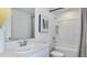 Well-lit bathroom featuring a large mirror, shower and bath combo with white tile and a neutral color scheme at 7811 Waterscape Dr, Groveland, FL 34736