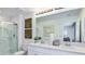 Spacious bathroom featuring double sinks, a shower with glass door, decorative accents, and modern lighting at 7811 Waterscape Dr, Groveland, FL 34736