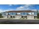 Modern townhome with light blue siding, a brown roof, and individual garages at 7811 Waterscape Dr, Groveland, FL 34736
