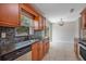 Updated kitchen with granite counters, stainless steel appliances, mosaic backsplash, and wood cabinetry at 811 Osceola Trl, Casselberry, FL 32707