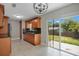 Open kitchen with wood cabinets, black appliances, decorative backsplash and sliding glass door at 811 Osceola Trl, Casselberry, FL 32707