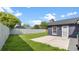 This backyard features a lush lawn, privacy fencing, mature trees, and a small patio area at 8111 Lianna Dr, Orlando, FL 32822