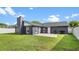 Back exterior view of a modern home featuring a patio area and lush, green lawn space at 8111 Lianna Dr, Orlando, FL 32822