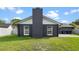 The home features a well-maintained lawn and a sleek exterior with white trim at 8111 Lianna Dr, Orlando, FL 32822