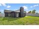 Exterior home view with manicured lawn, privacy fence, and modern dark-toned facade at 8111 Lianna Dr, Orlando, FL 32822