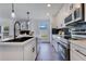 Modern kitchen with white cabinets, stainless appliances, and a view to a fireplace at 8111 Lianna Dr, Orlando, FL 32822