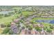Aerial view of a neighborhood with tile roofed homes around a lake and golf course at 8162 Prestbury Dr, Orlando, FL 32832