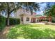 Spacious backyard with lush green lawn, covered patio, pergola, and mature landscaping at 8162 Prestbury Dr, Orlando, FL 32832
