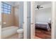 Tiled bathroom with a combination tub and shower, with toilet and door leading to bedroom at 8162 Prestbury Dr, Orlando, FL 32832