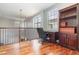 Upstairs loft with hardwood floors, large windows and a desk, creating a versatile space for work or relaxation at 8162 Prestbury Dr, Orlando, FL 32832