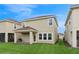 Back exterior view of the home, showcasing the lush backyard, patio, and outdoor grill at 8955 Fluffy Lie Ct, Davenport, FL 33896