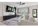 Cozy living room with large windows, plush seating, and contemporary entertainment center at 8955 Fluffy Lie Ct, Davenport, FL 33896
