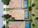 Aerial view of properties showcasing terra cotta roofs, screened in swimming pools, and well-manicured lawns at 9023 Shadow Mountain St, Davenport, FL 33896